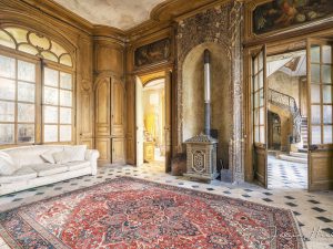Photographie d'un salon de château contenant un canapé et une cheminée.