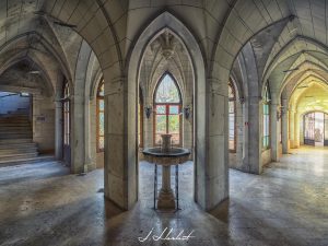 Photographie d'une fontaine présente dans un couloir de château.