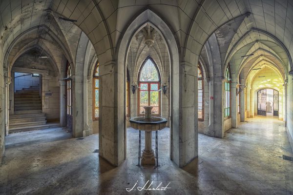 Photographie d'une fontaine présente dans un couloir de château.