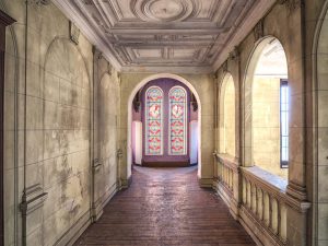 Photographie d'un couloir de château avec un plafond à reliefs.