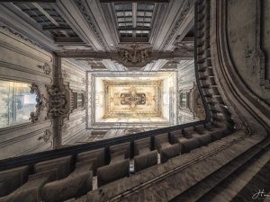 Photographie d'un plafond de château pris depuis le bas des escaliers.