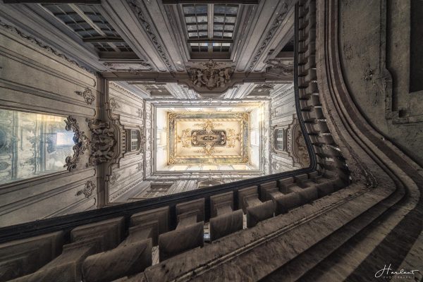 Photographie d'un plafond de château pris depuis le bas des escaliers.