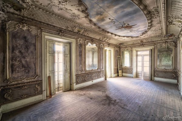 Photographie d'une pièce abandonnée avec un plafond peint.
