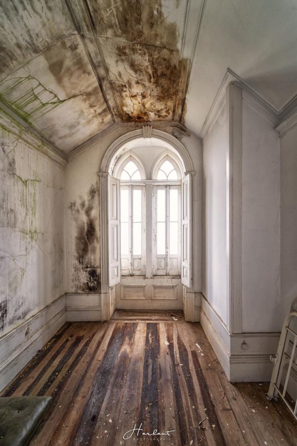 Photographie d'une fenêtre d'une chambre d'un château abandonné.