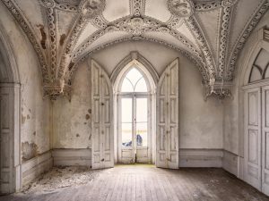 Photographie d'une fenêtre d'une chambre avec des moulures.