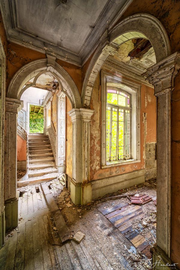 Photographie d'un couloir endommagé par le temps.