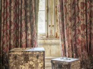 Photographie de caisses rouillées dans une chambre abandonnée
