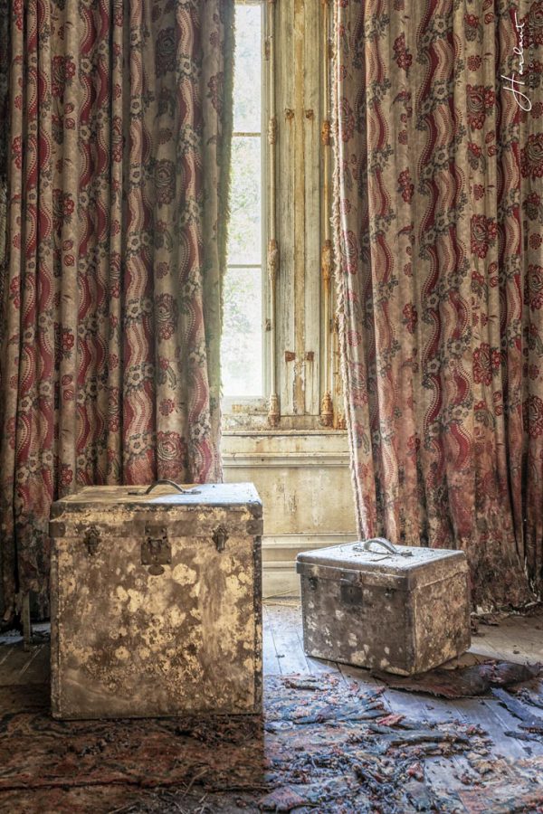 Photographie de caisses rouillées dans une chambre abandonnée