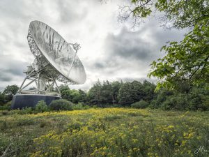 Photographie d'une antenne parabolique dans un champ