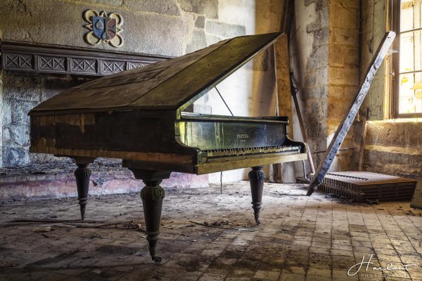 Photographie d'un vieux piano Pleyel dans une pièce abandonnée.