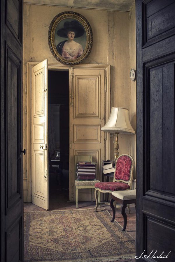 Photographie prise depuis un couloir montant une pièce avec une porte entre-ouverte.