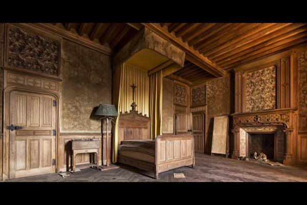 Photographie d'une chambre avec un lit dans un château.