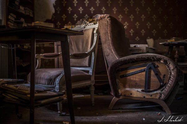 Photographie de fauteuils en velours abandonnés.