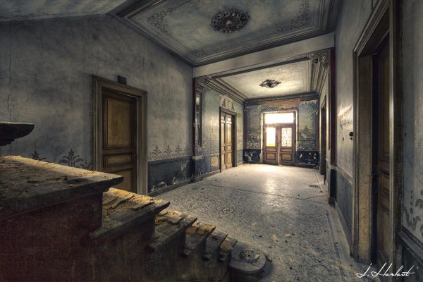 Photographie d'un hall d'une villa abandonnée.