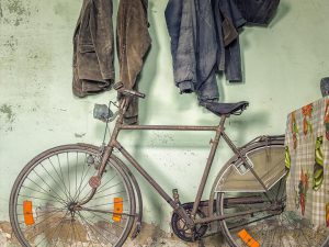 Photographie d'un vélo placé en dessous d'un porte manteau.