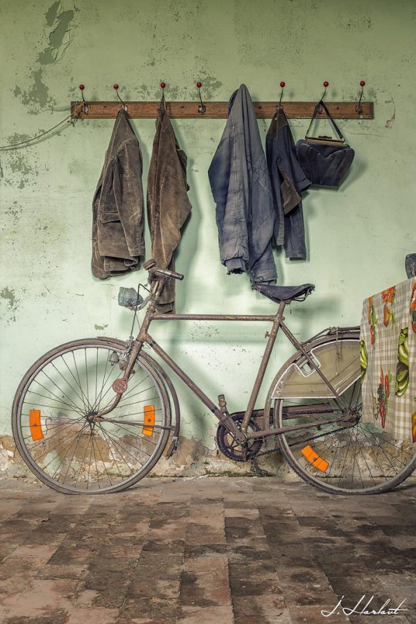 Photographie d'un vélo placé en dessous d'un porte manteau.