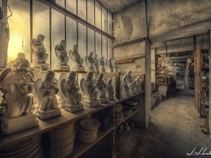 Photographie de statuettes entreposées dans un sous-sol.