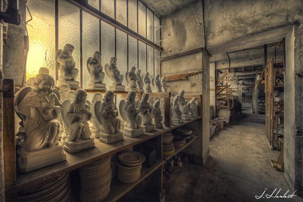 Photographie de statuettes entreposées dans un sous-sol.