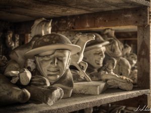 Photographie de statuettes entreposées sur des étagères.