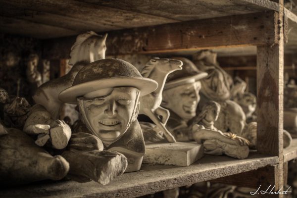 Photographie de statuettes entreposées sur des étagères.