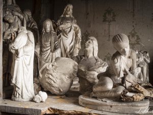 Photographie de statues religieuses entreposées sur une étagère.
