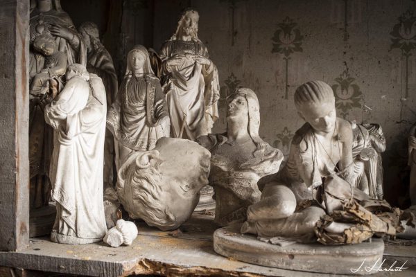 Photographie de statues religieuses entreposées sur une étagère.