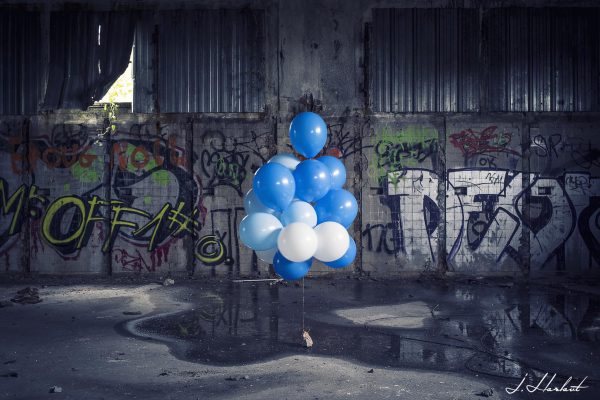 Photographie de ballons placés au milieu d'un hangar vide.
